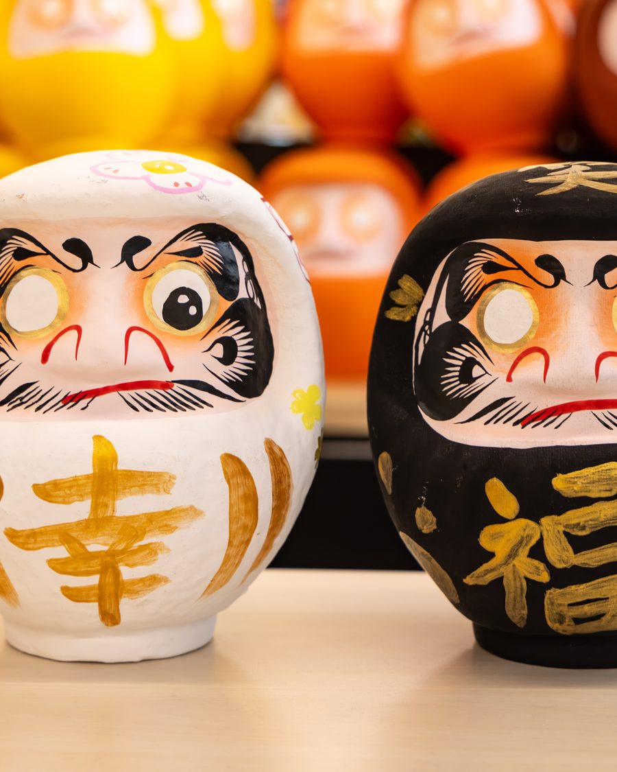 A white Daruma with the kanji for happiness and a black Daruma with the kanji for fortune, painted at DARUMA LAB. in Shinsaibashi, Osaka